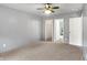 This carpeted bedroom includes a ceiling fan and access to a closet and attached bathroom at 7061 Blankenship Ave, Indianapolis, IN 46217