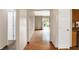 Hallway featuring laminate flooring, neutral paint, and an open view of the backyard through sliding glass doors at 7061 Blankenship Ave, Indianapolis, IN 46217