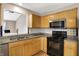 A well-lit kitchen featuring granite countertops and a black appliance set at 7061 Blankenship Ave, Indianapolis, IN 46217