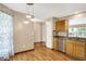 Updated kitchen featuring stainless steel appliances, granite countertops, natural wood cabinets, and laminate floors at 7061 Blankenship Ave, Indianapolis, IN 46217