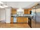 Updated kitchen featuring stainless steel appliances, granite countertops, natural wood cabinets, and laminate floors at 7061 Blankenship Ave, Indianapolis, IN 46217