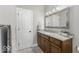 Bathroom features a wooden vanity with granite countertop, decorative mirror, and modern fixtures at 7648 Killarney Dr, Indianapolis, IN 46217