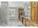 This luxurious bathroom has a stand-up shower, double vanity, linen cabinet, and large window at 7648 Killarney Dr, Indianapolis, IN 46217