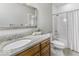 Bright bathroom features granite counters, wood cabinets, and a shower and tub with white tile surround at 7648 Killarney Dr, Indianapolis, IN 46217