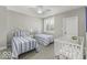 Comfortable bedroom featuring twin beds, soft natural light, and a cute baby crib at 7648 Killarney Dr, Indianapolis, IN 46217
