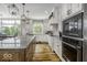 Bright kitchen featuring an island, hardwood floors, granite countertops, and modern stainless steel appliances at 7648 Killarney Dr, Indianapolis, IN 46217