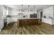 A chef's kitchen with an island, wood flooring, stainless steel appliances and pendant lighting at 7648 Killarney Dr, Indianapolis, IN 46217