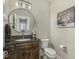 Cozy powder room with a decorative mirror, granite countertop, and wood vanity at 7648 Killarney Dr, Indianapolis, IN 46217