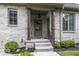 Charming side entrance with covered porch, brick accents, and well-maintained landscaping at 7648 Killarney Dr, Indianapolis, IN 46217