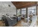 Cozy sunroom with wood paneled ceiling, brick walls, and plush seating with a view of the backyard at 7648 Killarney Dr, Indianapolis, IN 46217