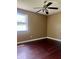 Empty bedroom with hardwood floors, a ceiling fan, and a bright window at 7824 Hearthstone Way, Indianapolis, IN 46227