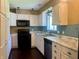 Bright kitchen featuring white cabinets, marble countertops, and black appliances at 7824 Hearthstone Way, Indianapolis, IN 46227