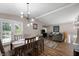 Open-concept dining area with a wooden table, modern lighting, and views into the living room and outdoor deck at 7831 Eagle Valley Pass, Indianapolis, IN 46214
