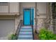Close-up of a vibrant blue front door with decorative glass, accented by stone facade and manicured landscaping at 7831 Eagle Valley Pass, Indianapolis, IN 46214
