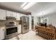 Bright kitchen featuring white cabinets, stainless steel appliances, granite countertops, and an open view to the dining area at 7831 Eagle Valley Pass, Indianapolis, IN 46214