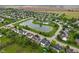 Expansive aerial view showcasing a neighborhood with a pond, swimming pool, and tennis courts bordered by farmland at 7978 Park Meadows Dr, Brownsburg, IN 46112