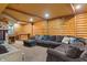 Finished basement with large sectional sofa, log walls, and a cozy bar area at 7978 Park Meadows Dr, Brownsburg, IN 46112