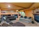Basement living room featuring wood beams, stone fireplace, comfortable sofa and bunk beds in the background at 7978 Park Meadows Dr, Brownsburg, IN 46112