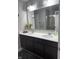 Bathroom featuring double sinks, a large mirror, vanity, and modern fixtures at 8241 Morera Ct, Indianapolis, IN 46237