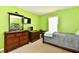 Bright green bedroom featuring wooden furniture and a convenient shoe rack at 8325 Chesterhill Ln, Indianapolis, IN 46239