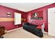 Red bedroom featuring a comfortable single bed and Florida Seminoles decor at 8325 Chesterhill Ln, Indianapolis, IN 46239