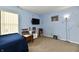 Bedroom with neutral carpet, blue accent wall decorated with music notes, lamp and tv at 8325 Chesterhill Ln, Indianapolis, IN 46239