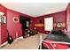 Nicely decorated red bedroom featuring guitars, flatscreen TVs, and a cozy bed at 8325 Chesterhill Ln, Indianapolis, IN 46239