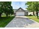 A charming home with a two-car garage, long drive and green front yard, providing curb appeal and practicality at 8325 Chesterhill Ln, Indianapolis, IN 46239