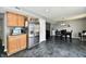 Open kitchen and dining area with stainless steel refrigerator, gray marbled floor, and light wood cabinets at 8325 Chesterhill Ln, Indianapolis, IN 46239
