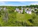 An aerial shot of houses with large yards and tree lines in a neighborhood, taken on a bright, clear day with blue skies at 8631 Belle Union Pl, Indianapolis, IN 46113