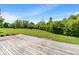 A lush green backyard with a wooden deck offers a tranquil outdoor living space perfect for relaxation and entertaining at 8631 Belle Union Pl, Indianapolis, IN 46113