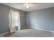 Bedroom featuring neutral gray walls, carpet flooring, and a window with curtains at 8631 Belle Union Pl, Indianapolis, IN 46113