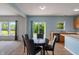 Open dining room with wood floors, a round table and backyard views at 8631 Belle Union Pl, Indianapolis, IN 46113