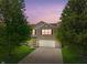 Charming two-story brick home with a well-manicured lawn and attached two-car garage at dusk at 8631 Belle Union Pl, Indianapolis, IN 46113