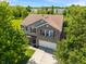 An aerial front view of the home showcasing the front entry, the roof, driveway, landscaping, and mature shade trees at 8631 Belle Union Pl, Indianapolis, IN 46113