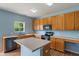 Well-lit kitchen with oak cabinets, an island, and modern appliances at 8631 Belle Union Pl, Indianapolis, IN 46113