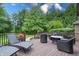 Back deck with lounge chairs, wicker furniture, and mature trees in a lush backyard setting at 876 Box Turtle Ct, Columbus, IN 47201