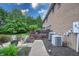 Home exterior with expansive backyard, featuring deck with furniture, A/C units, and lush landscaping at 876 Box Turtle Ct, Columbus, IN 47201