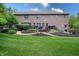 Spacious backyard with lush lawn, mulch garden beds, flowering plants, and a deck with furniture at 876 Box Turtle Ct, Columbus, IN 47201