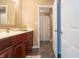 This bathroom features a vanity with a dark wood cabinet, neutral countertop, and doorway leading to shower/toilet at 876 Box Turtle Ct, Columbus, IN 47201