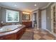 Bathroom with a soaking tub, vanity, and an open doorway to the toilet area at 876 Box Turtle Ct, Columbus, IN 47201