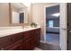 Bathroom vanity with dark cabinets, large mirror and doorway to bedroom at 876 Box Turtle Ct, Columbus, IN 47201