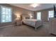 Bedroom with neutral walls, carpet, white trim and a large bed centered between two windows at 876 Box Turtle Ct, Columbus, IN 47201