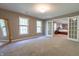 This room features neutral carpet, large windows and and open doorway leading to another bedroom at 876 Box Turtle Ct, Columbus, IN 47201