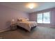 This spacious bedroom features neutral carpet, a large window and a plush bed with decorative pillows at 876 Box Turtle Ct, Columbus, IN 47201