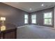 Spacious bedroom featuring neutral carpeting, three windows bringing in natural light, and a classic wood dresser at 876 Box Turtle Ct, Columbus, IN 47201