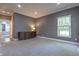 Inviting bedroom with a neutral color scheme, plush carpeting, large windows, and a beautiful, carved dresser at 876 Box Turtle Ct, Columbus, IN 47201