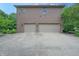 Two-car garage with concrete driveway, brick siding, and manicured landscaping, providing ample parking at 876 Box Turtle Ct, Columbus, IN 47201