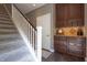Carpeted staircase with white spindles and dark wood railing, paired with dark cabinetry for storage, leads to upper levels at 876 Box Turtle Ct, Columbus, IN 47201