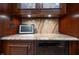 Finished basement bar top featuring granite counters, wine fridge, and display cabinets at 876 Box Turtle Ct, Columbus, IN 47201